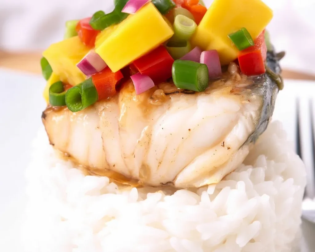 Delicious grilled wahoo fish with mango salsa and spices on a plate.